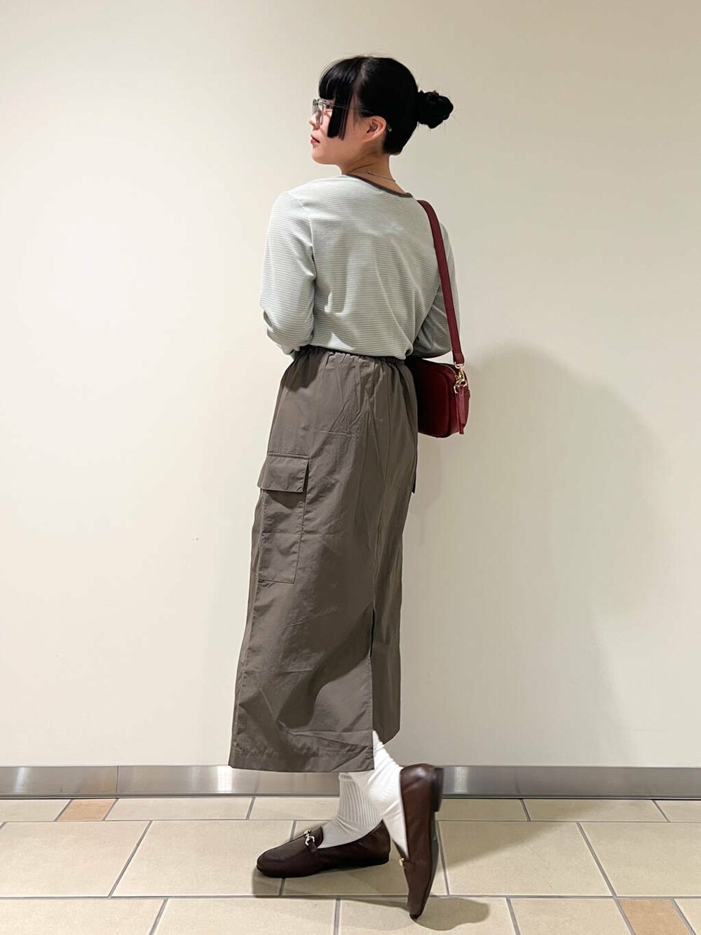 ブラウン系のローファー、レッド系のショルダーバッグ、ベージュ系のTシャツ/カットソーを着用したレディースの春コーディネートの2枚目の写真