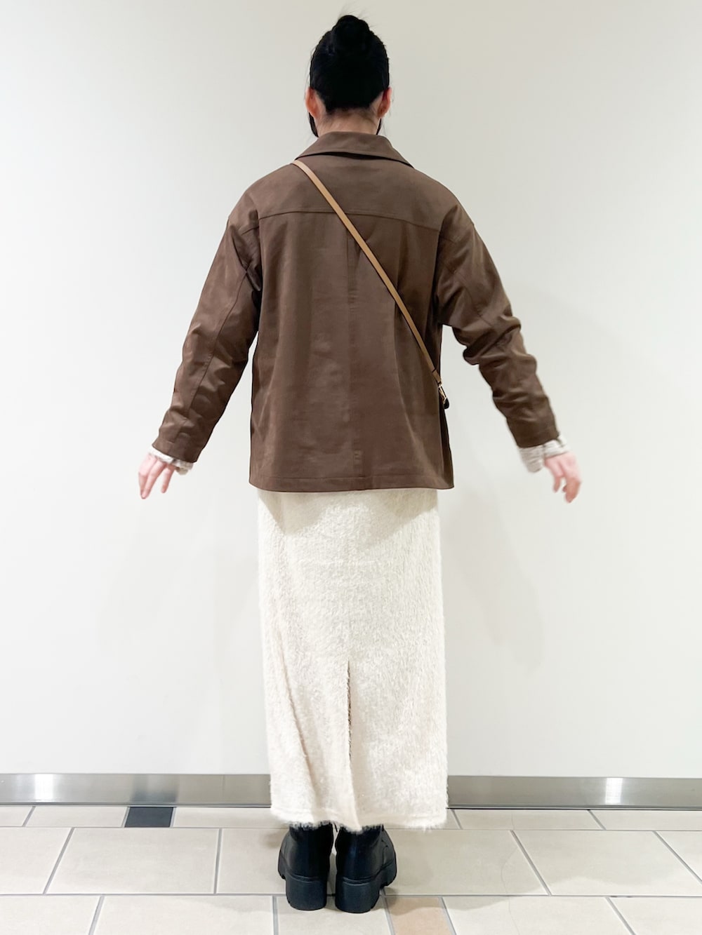 ベージュ系のニット/セーター、ブラウン系のその他アウター、ホワイト系のスカートを着用したレディースの冬コーディネートの3枚目の写真