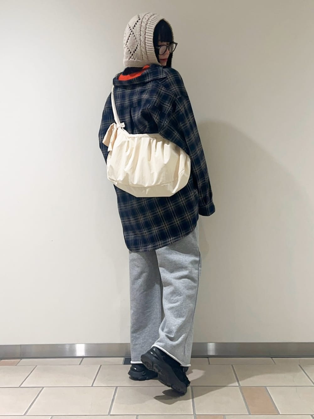 オレンジ系のニット/セーター、ブルー系のシャツ/ブラウス、グレー系のその他パンツを着用したレディースの冬コーディネートの3枚目の写真