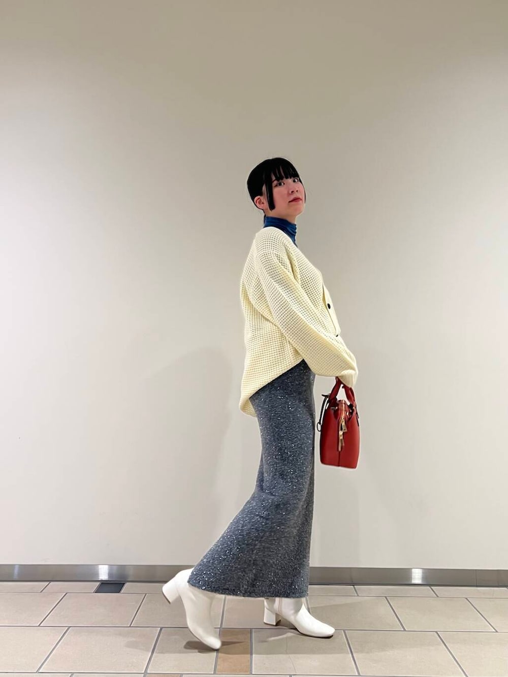 ホワイト系のブーツ、ブルー系のTシャツ/カットソー、ホワイト系のカーディガン/ボレロを着用したレディースの秋コーディネートの2枚目の写真