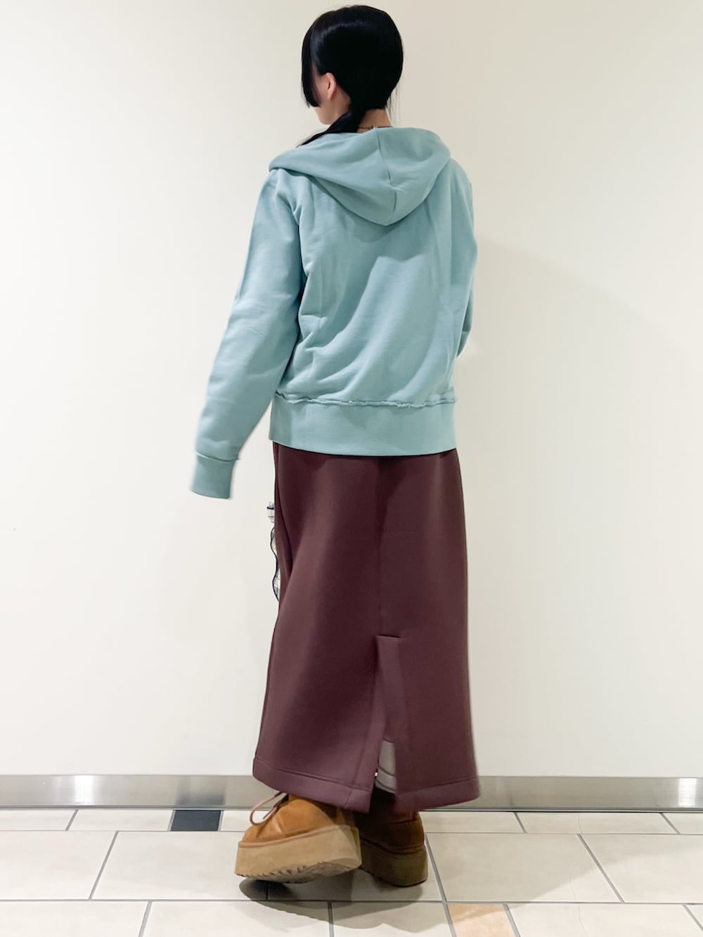 グレー系のTシャツ/カットソー、ブラウン系のスカート、グリーン系のパーカーを着用したレディースの春コーディネートの2枚目の写真