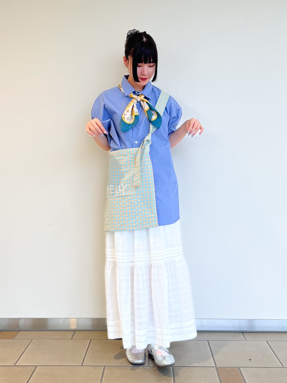 ホワイト系のスカート、ブルー系のシャツ/ブラウス、イエロー系のバンダナ/スカーフを着用したレディースの夏コーディネートの2枚目の写真