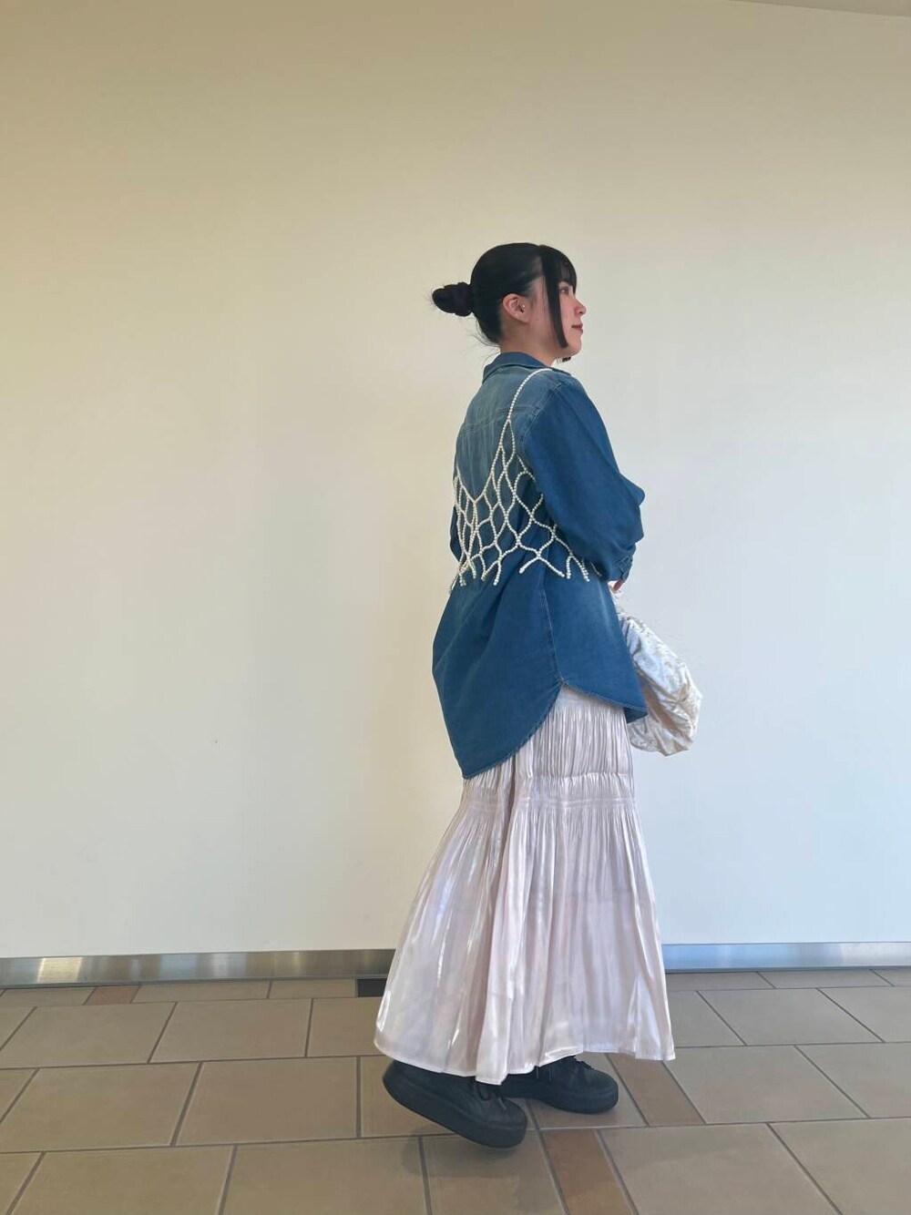 ベージュ系のハンドバッグ、ブルー系のシャツ/ブラウス、ホワイト系のスカートを着用したレディースの秋コーディネートの2枚目の写真