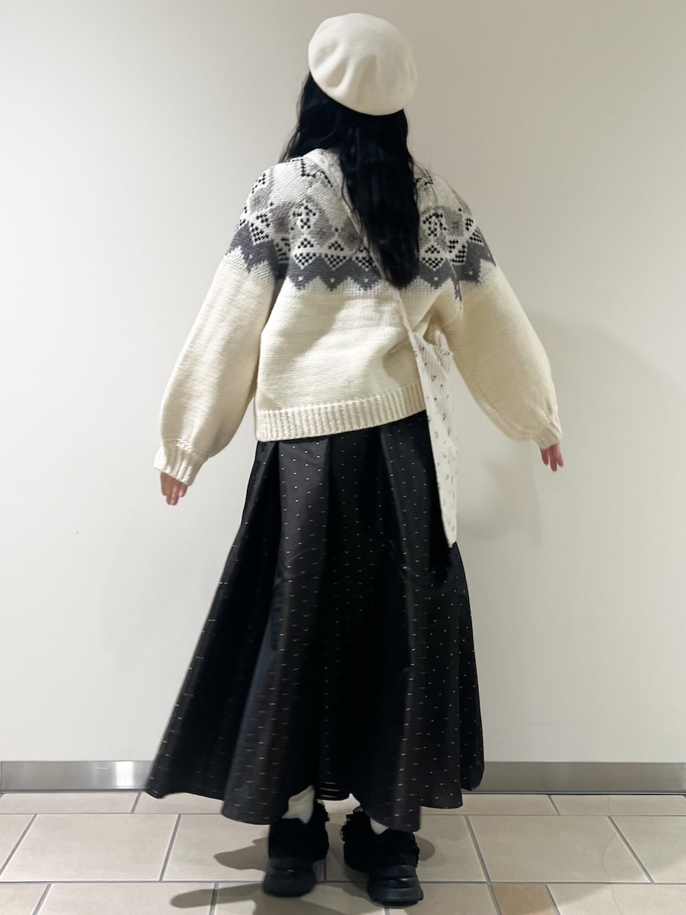 ホワイト系のカーディガン/ボレロ、ベージュ系のショルダーバッグ、ブラウン系のスカートを着用したレディースの冬コーディネートの2枚目の写真