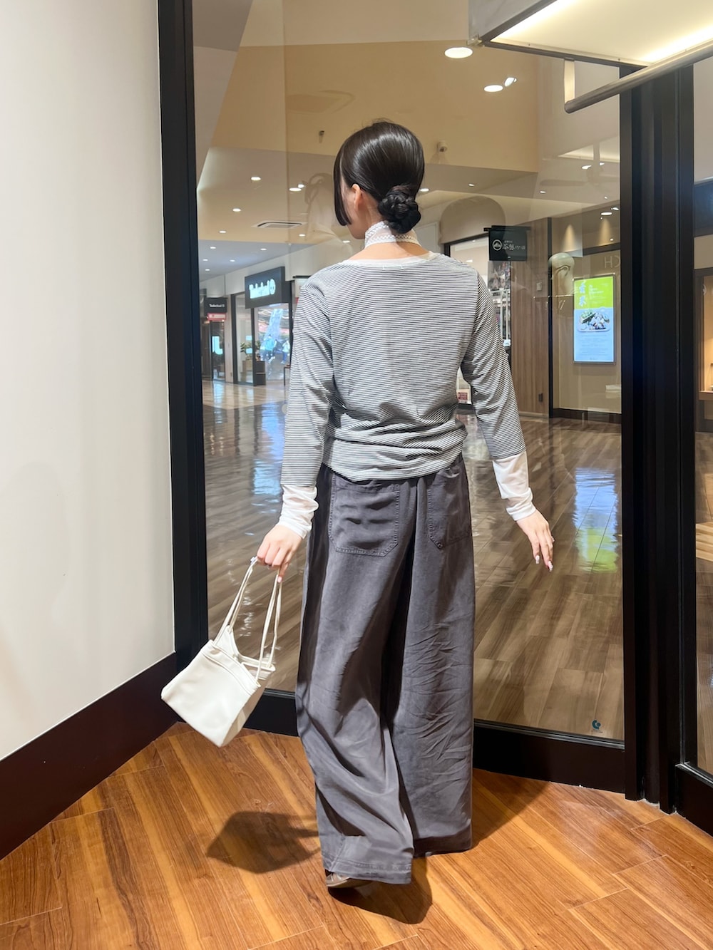ホワイト系のTシャツ/カットソー、グレー系のその他パンツ、ホワイト系のハンドバッグを着用したレディースの秋コーディネートの2枚目の写真