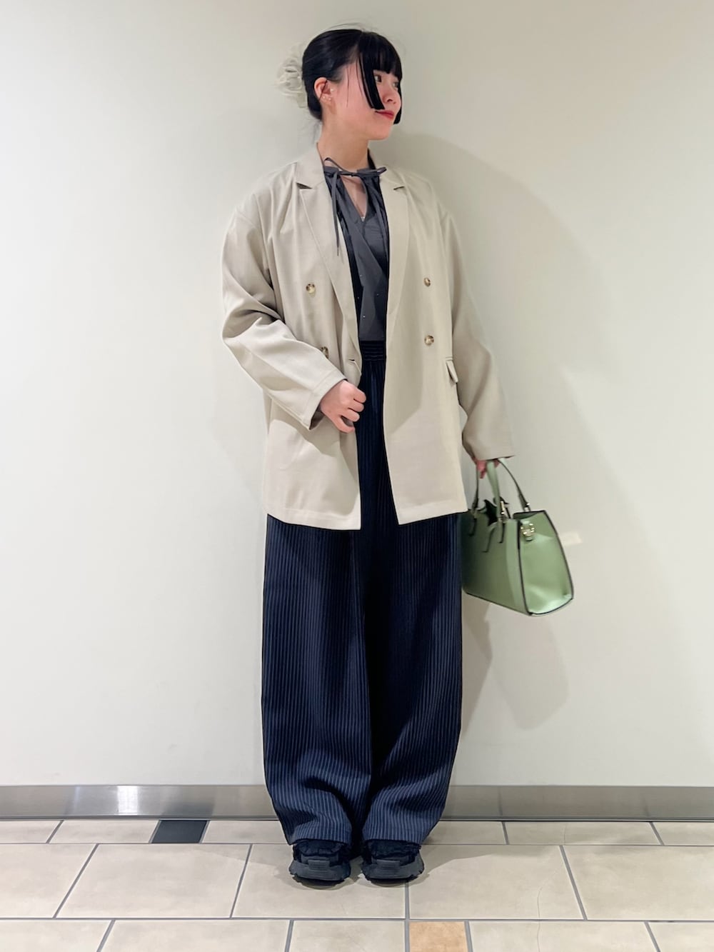 その他のその他パンツ、グリーン系のハンドバッグ、ベージュ系のその他アウターを着用したレディースの春コーディネートの2枚目の写真