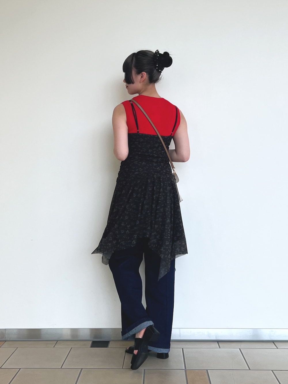 レッド系のニット/セーター、ブラック系のワンピース、ブルー系のデニムパンツを着用したレディースの夏コーディネートの2枚目の写真