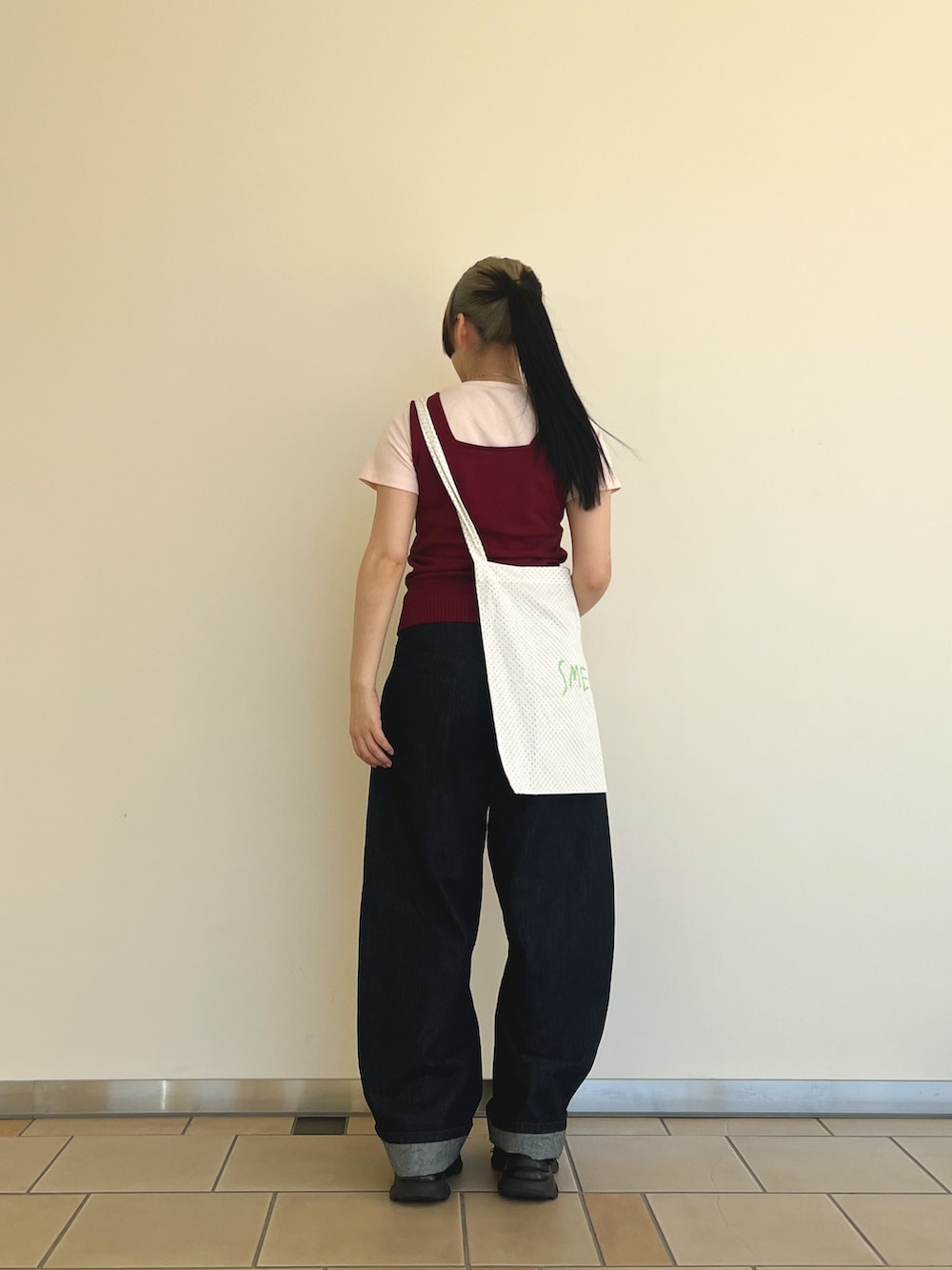 ホワイト系のショルダーバッグ、ピンク系のTシャツ/カットソー、レッド系のニット/セーターを着用したレディースの夏コーディネートの2枚目の写真
