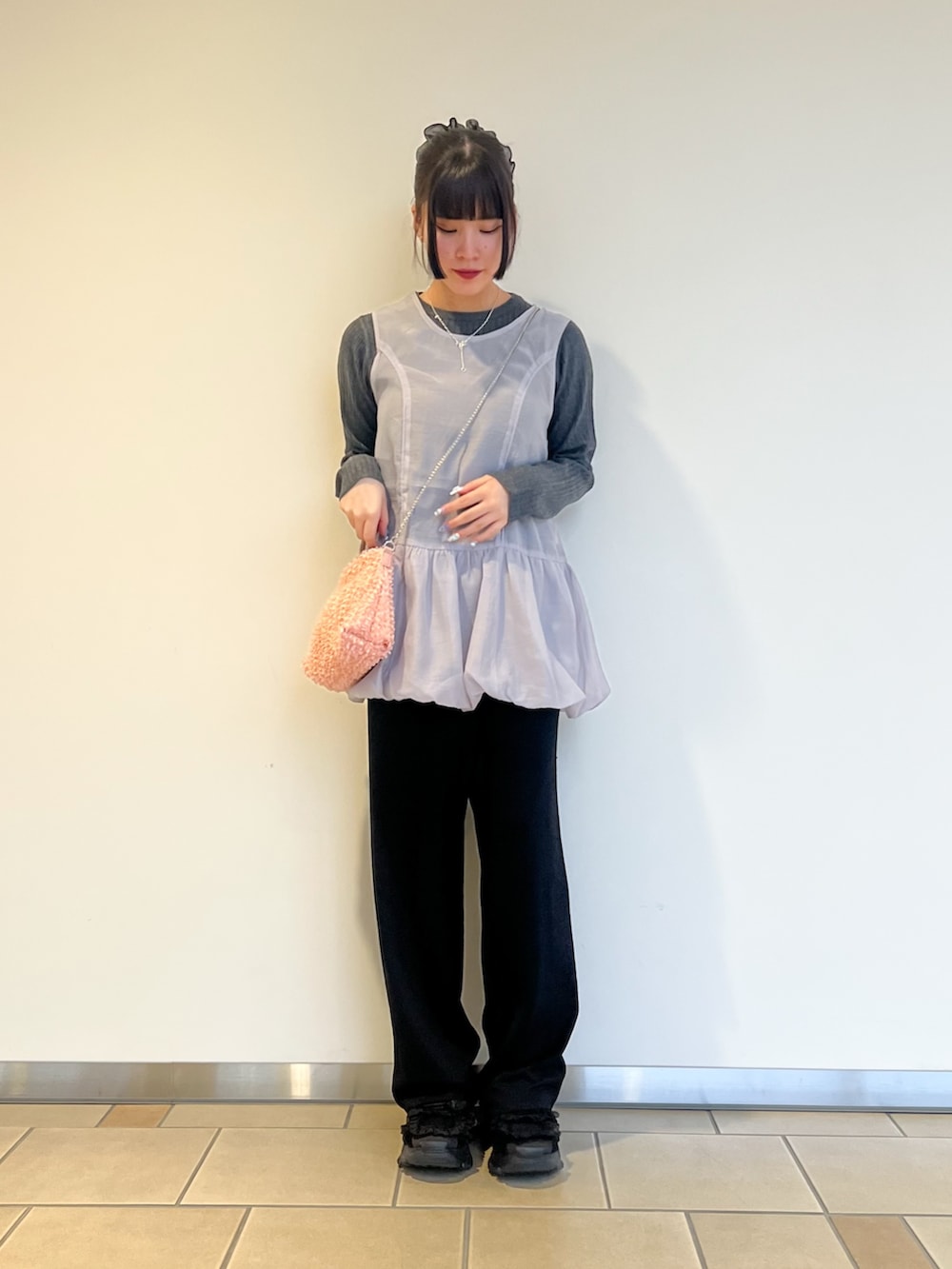 グレー系のニット/セーター、ブラック系のその他パンツ、ピンク系のショルダーバッグを着用したレディースの秋コーディネートの2枚目の写真