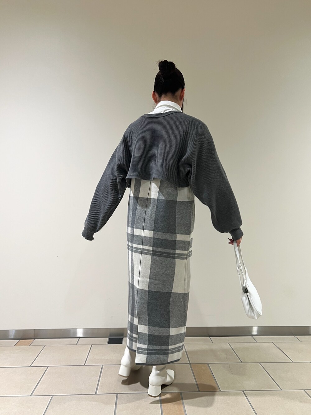 グレー系のワンピース、ホワイト系のハンドバッグ、ホワイト系のTシャツ/カットソーを着用したレディースの秋コーディネートの4枚目の写真
