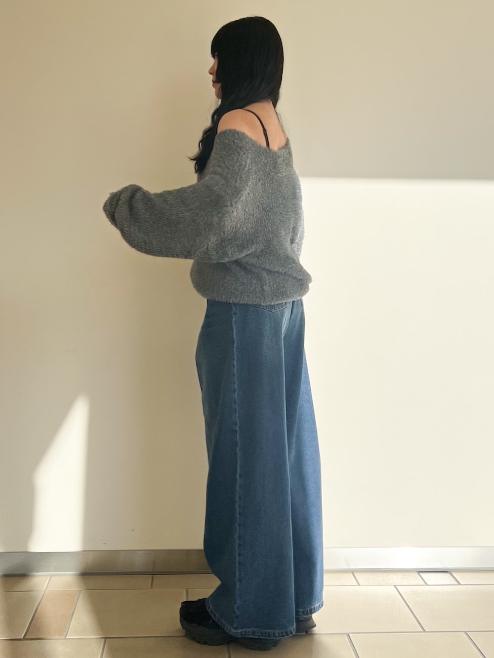 グリーン系のニット/セーター、ブルー系のデニムパンツ、ブラック系のショルダーバッグを着用したレディースの冬コーディネートの2枚目の写真