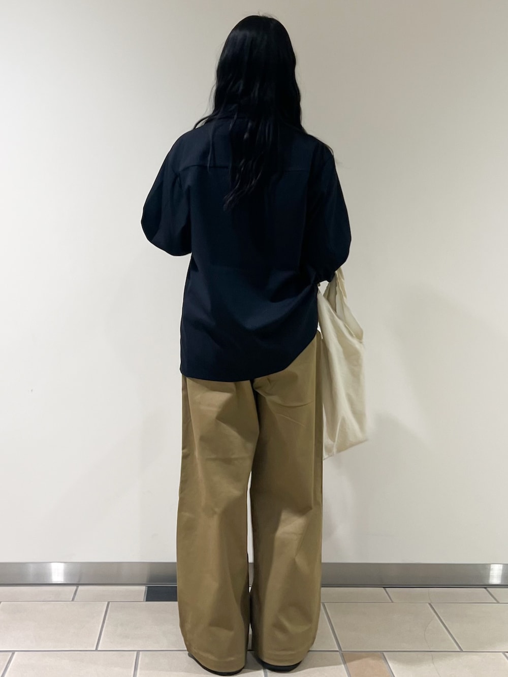 ブルー系のその他アウター、ホワイト系のトートバッグ、イエロー系のその他パンツを着用したレディースの冬コーディネートの2枚目の写真