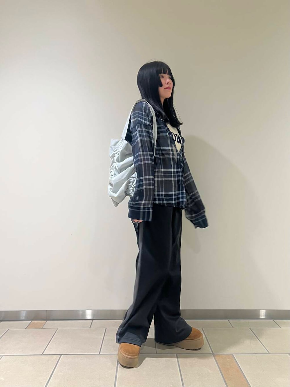 ブラック系のその他パンツ、グレー系のトートバッグ、ブルー系のシャツ/ブラウスを着用したレディースの春コーディネートの2枚目の写真