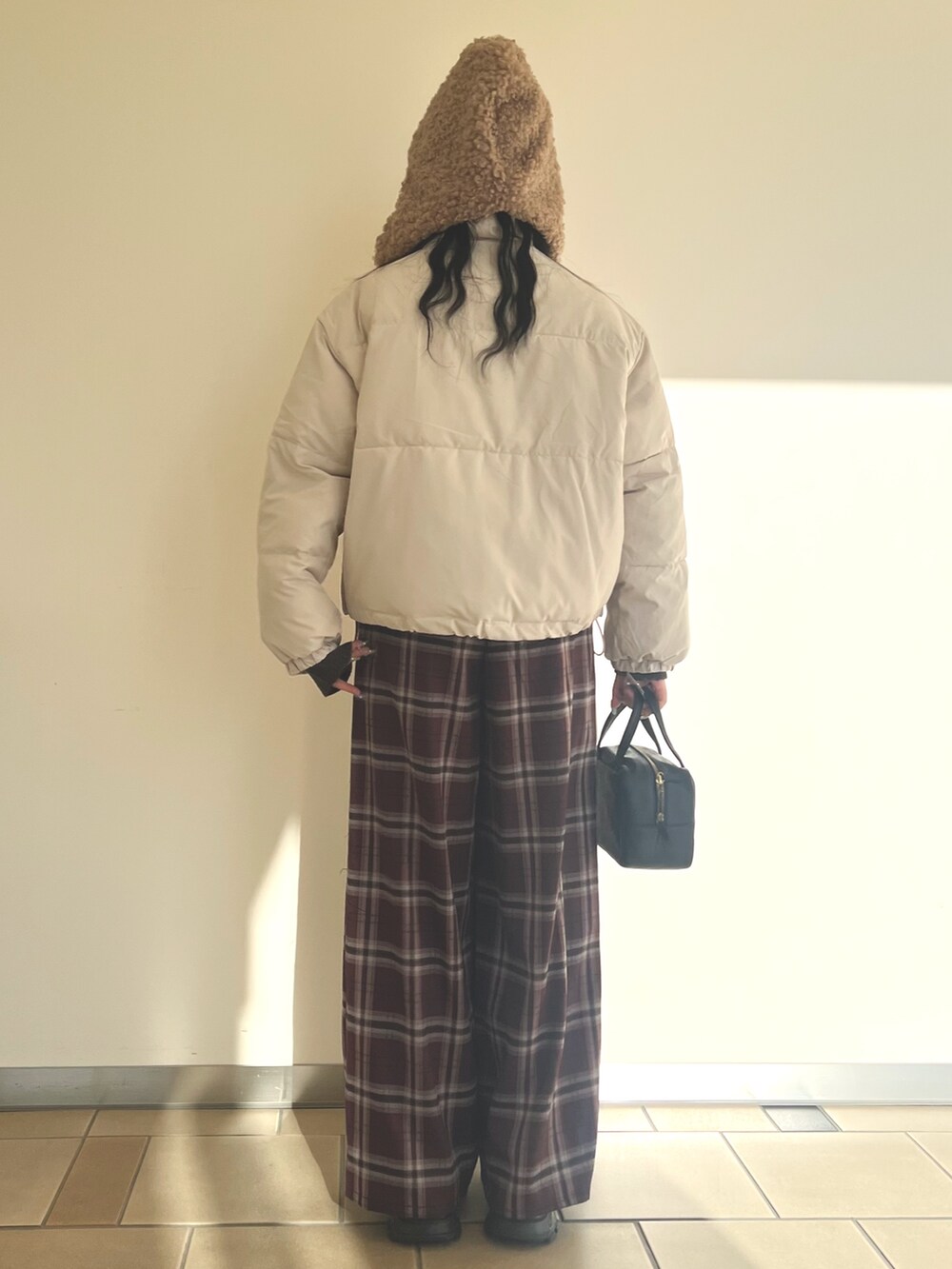 グレー系のダウンジャケット/コート、ブラウン系のニット/セーター、レッド系のその他パンツを着用したレディースの冬コーディネートの2枚目の写真