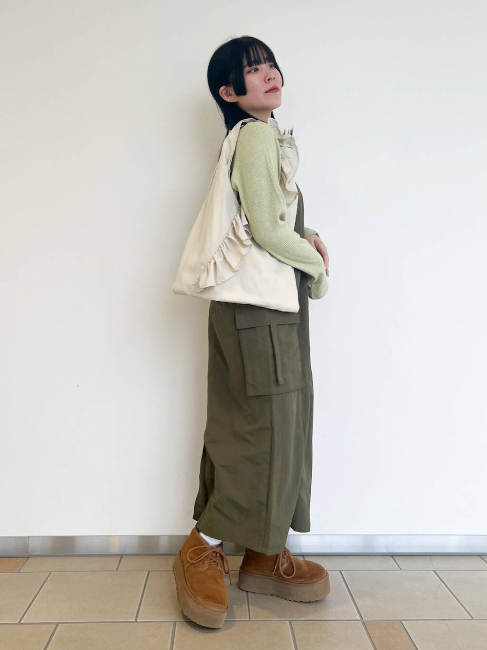 グリーン系のTシャツ/カットソー、ホワイト系のトートバッグ、グリーン系のワンピースを着用したレディースの春コーディネートの2枚目の写真