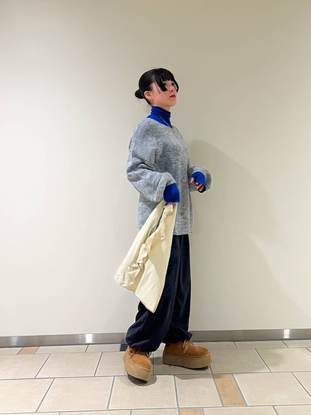 ブルー系のその他パンツ、ブルー系のTシャツ/カットソー、ホワイト系のトートバッグを着用したレディースの冬コーディネートの2枚目の写真