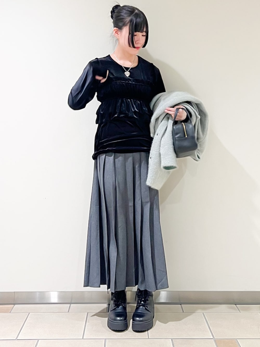 ブルー系のその他アウター、ブラック系のTシャツ/カットソー、グレー系のスカートを着用したレディースの冬コーディネートの2枚目の写真