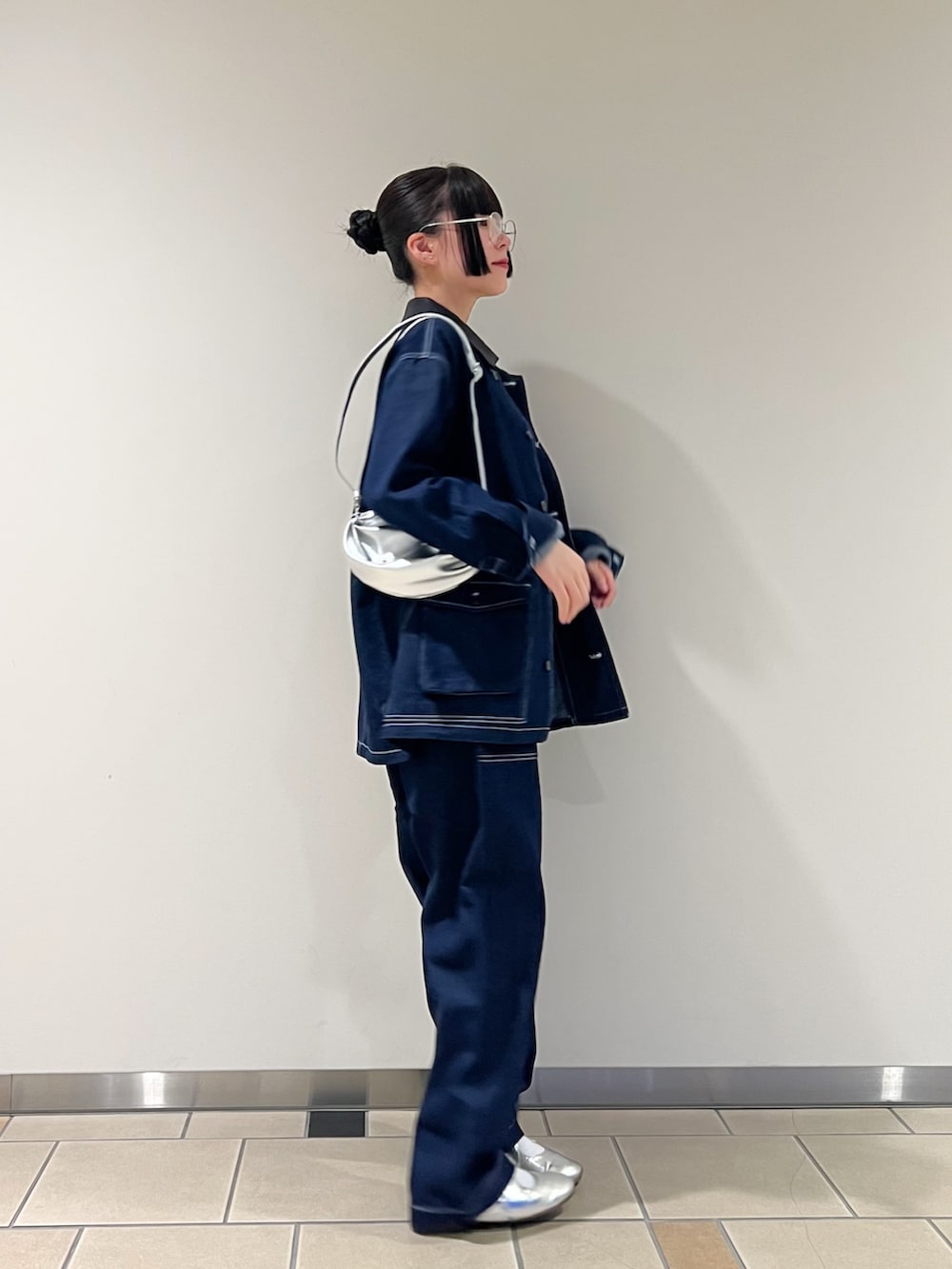 グリーン系のタンクトップ、シルバー系のショルダーバッグ、シルバー系のメガネを着用したレディースの秋コーディネートの2枚目の写真