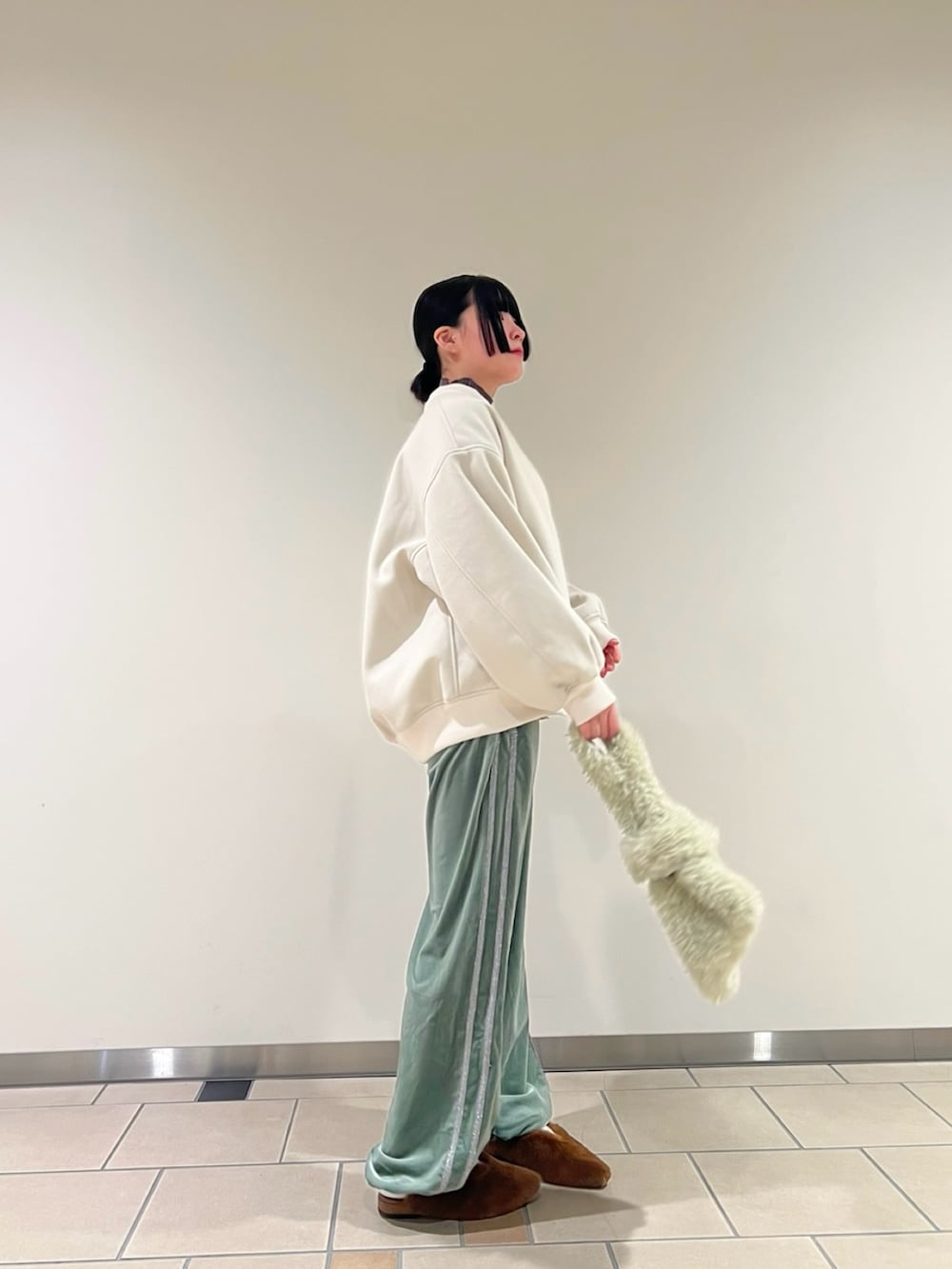 グレー系のニット/セーター、イエロー系のその他シューズ、グリーン系のその他パンツを着用したレディースの冬コーディネートの2枚目の写真