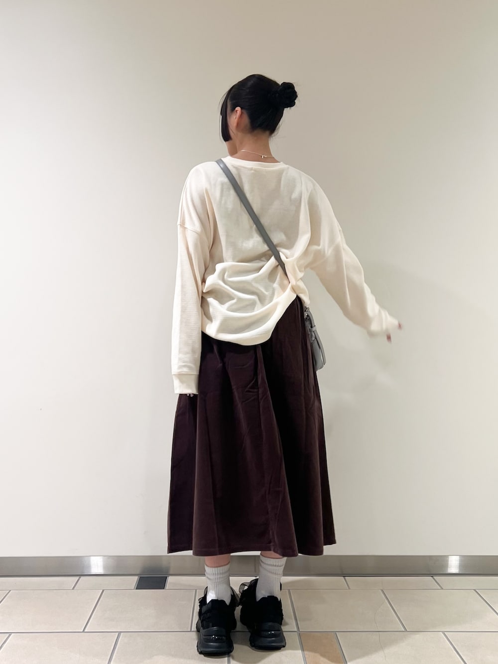 ホワイト系のTシャツ/カットソー、ブラウン系のスカート、グレー系のショルダーバッグを着用したレディースの秋コーディネートの2枚目の写真