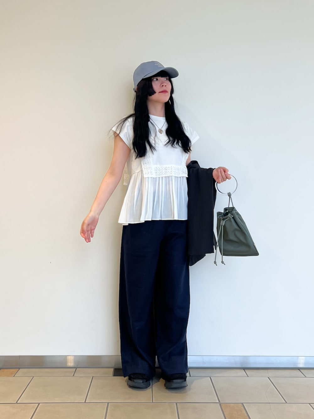 ホワイト系のTシャツ/カットソー、グレー系のダウンベスト、ブルー系のその他パンツを着用したレディースの春コーディネートの2枚目の写真