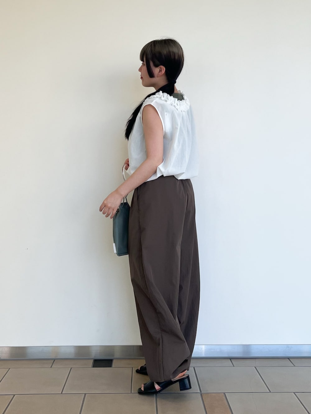 ブラウン系のその他パンツ、ホワイト系のシャツ/ブラウス、グリーン系のニット/セーターを着用したレディースの夏コーディネートの2枚目の写真