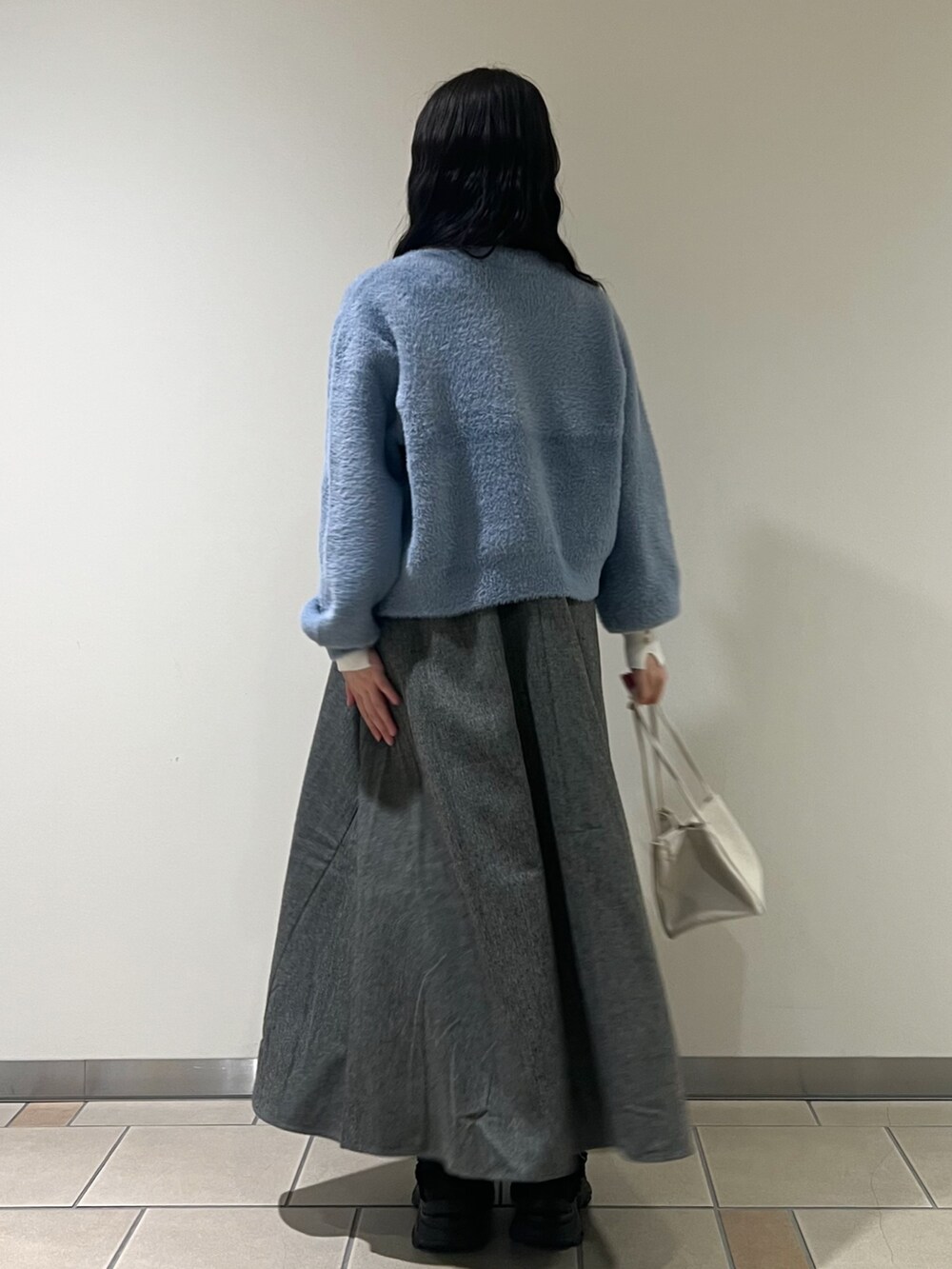 ブラック系のワンピース、ブルー系のカーディガン/ボレロ、ホワイト系のニット/セーターを着用したレディースの秋コーディネートの2枚目の写真