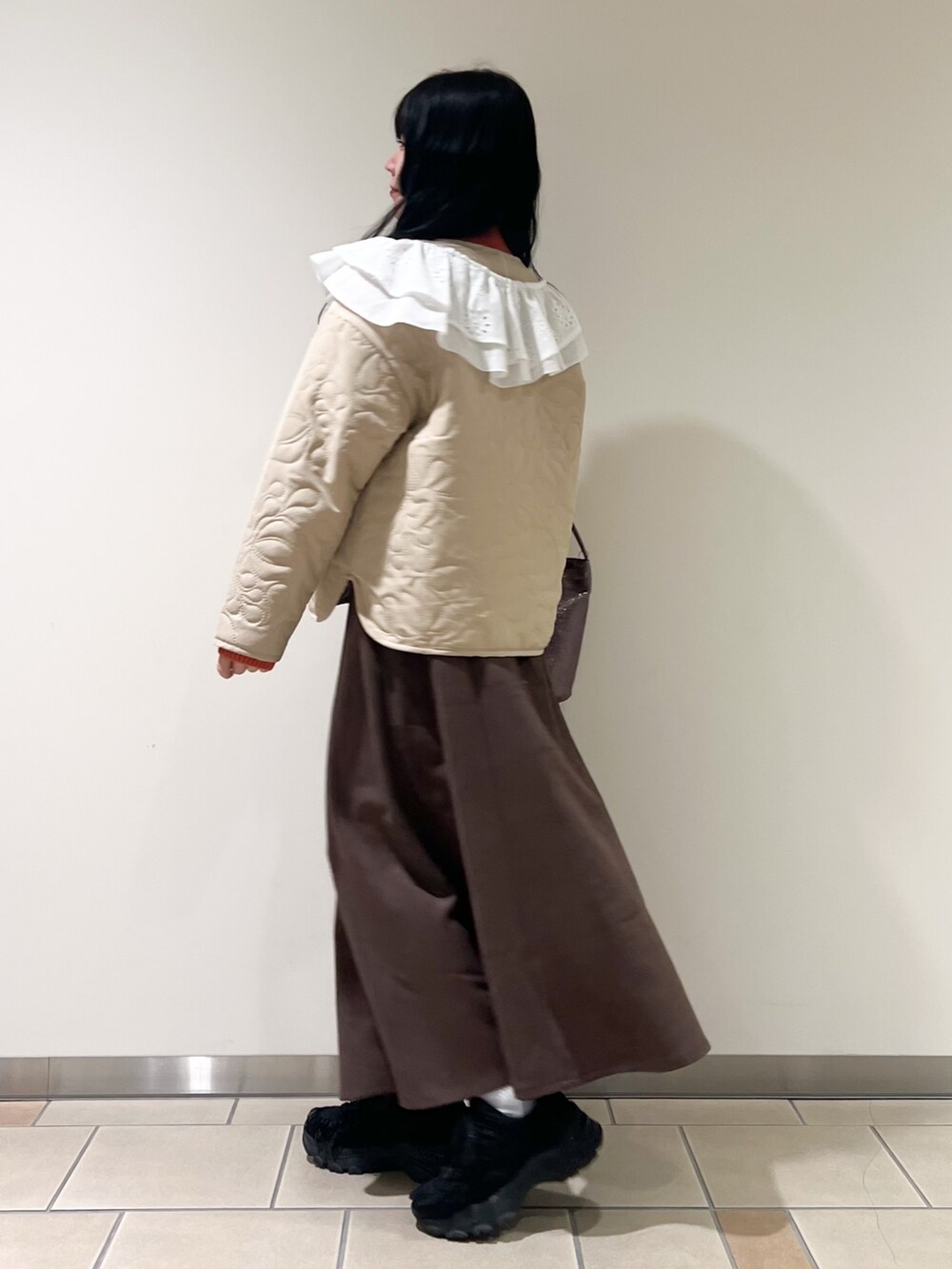 ブラウン系のスカート、ベージュ系のノーカラージャケット、オレンジ系のニット/セーターを着用したレディースの秋コーディネートの3枚目の写真