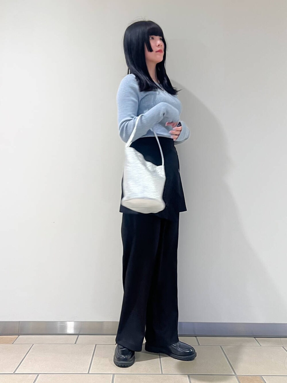シルバー系のハンドバッグ、ブルー系のニット/セーター、ブラック系のその他パンツを着用したレディースの春コーディネートの2枚目の写真