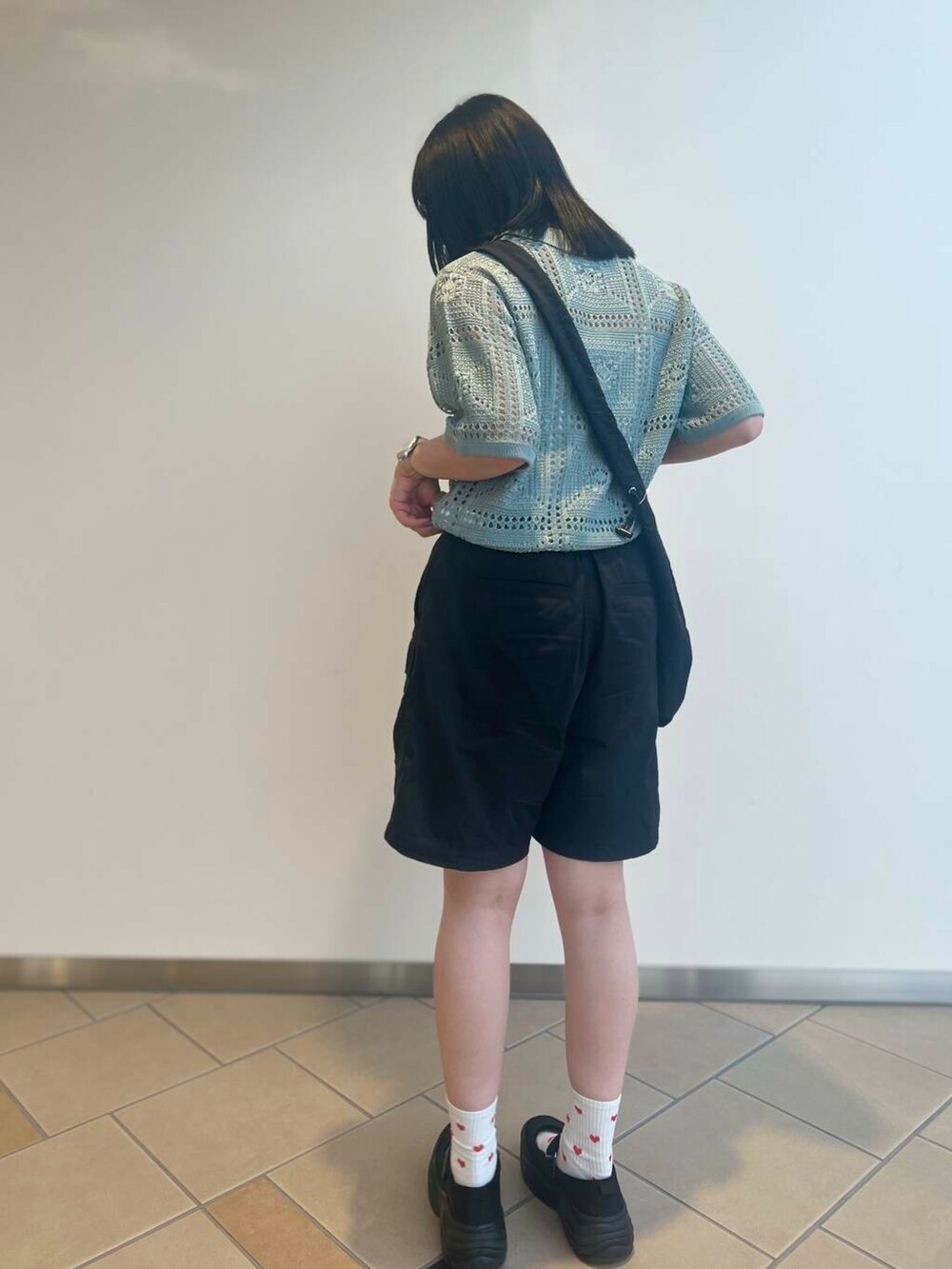 ブラック系のショルダーバッグ、グリーン系のニット/セーター、ブラック系のその他パンツを着用したレディースの夏コーディネートの3枚目の写真