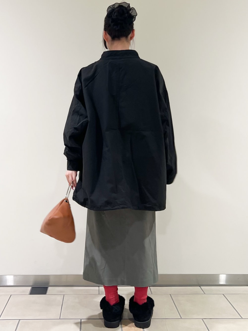 グレー系のスウェット、ブラック系のモッズコート、グリーン系のスカートを着用したレディースの冬コーディネートの4枚目の写真