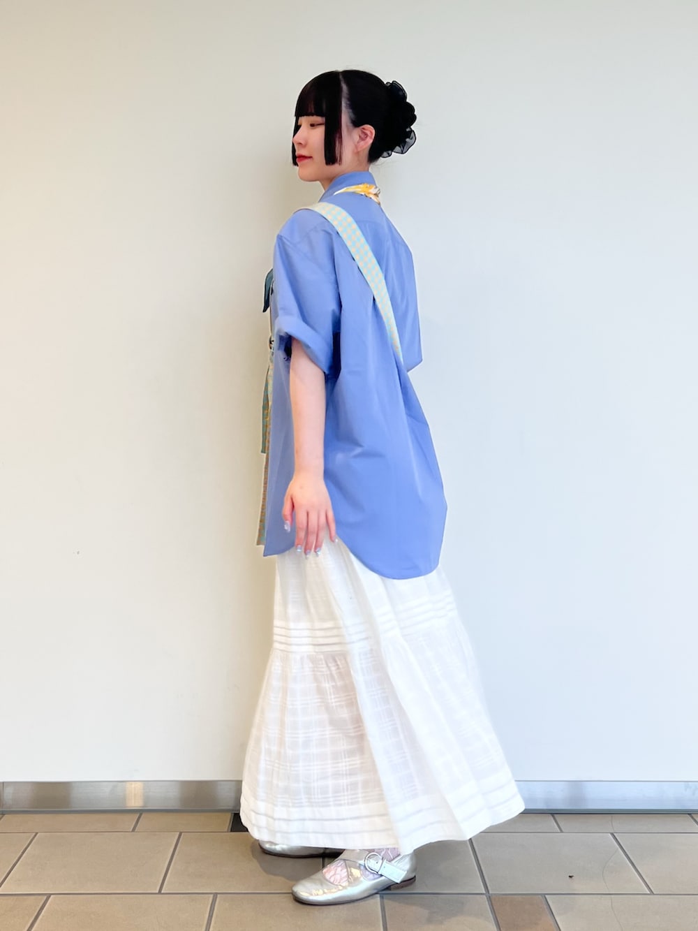 ホワイト系のスカート、ブルー系のシャツ/ブラウス、イエロー系のバンダナ/スカーフを着用したレディースの夏コーディネートの3枚目の写真