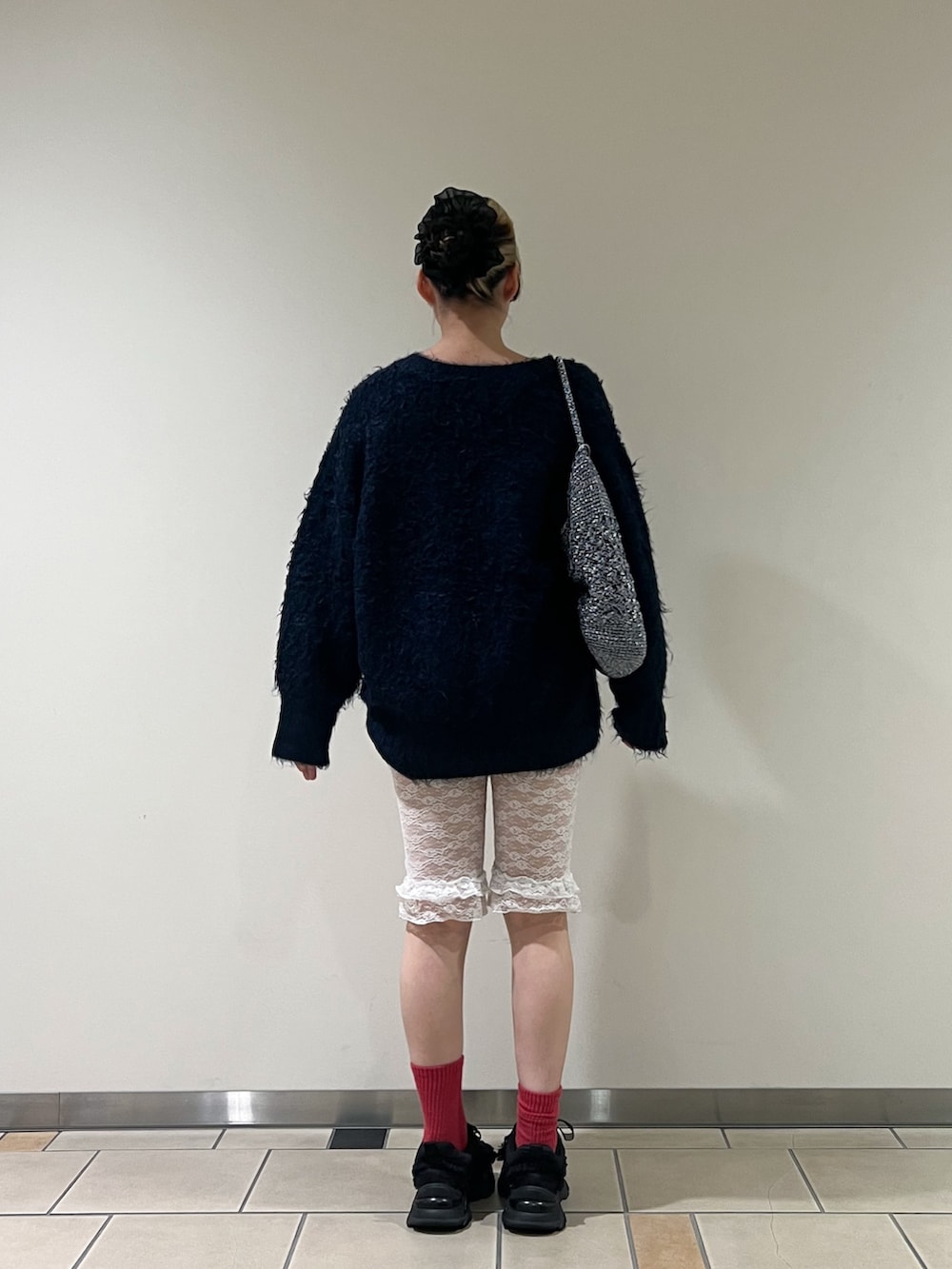 ブルー系のカーディガン/ボレロ、グリーン系のニット/セーター、ブルー系のかごバッグを着用したレディースの秋コーディネートの3枚目の写真