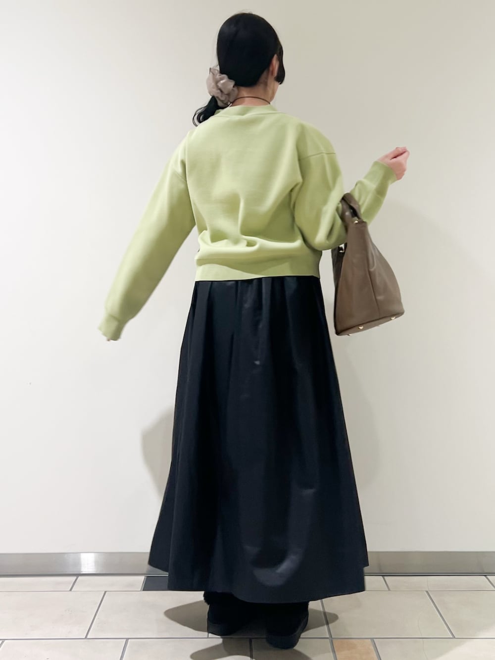 ブラック系のスカート、グリーン系のカーディガン/ボレロ、ホワイト系のタンクトップを着用したレディースの春コーディネートの2枚目の写真