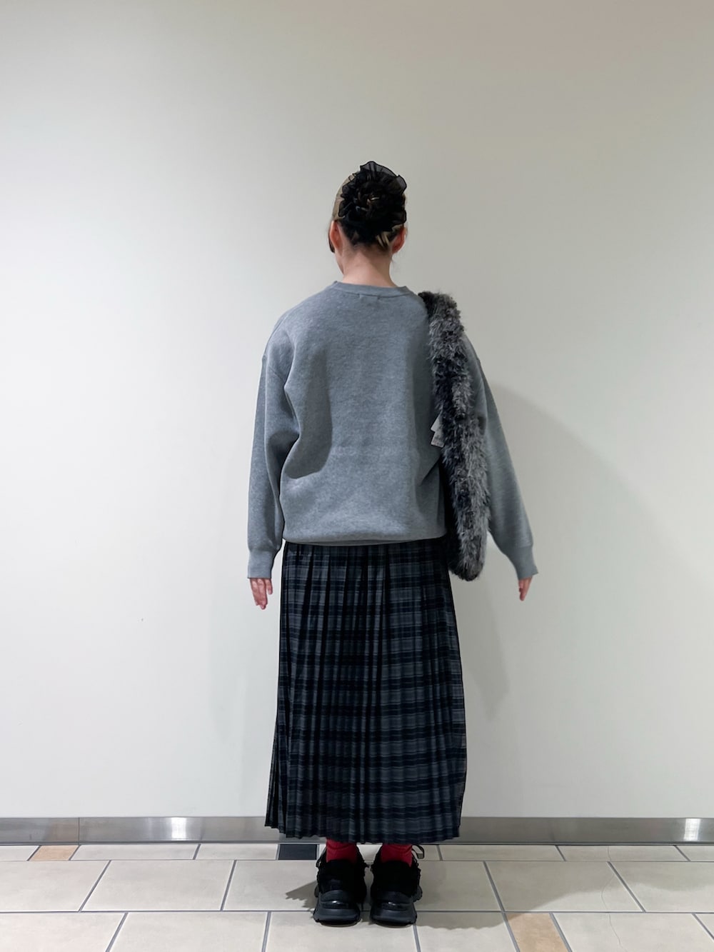 ブルー系のスカート、グレー系のトートバッグを着用したレディースの秋コーディネートの3枚目の写真