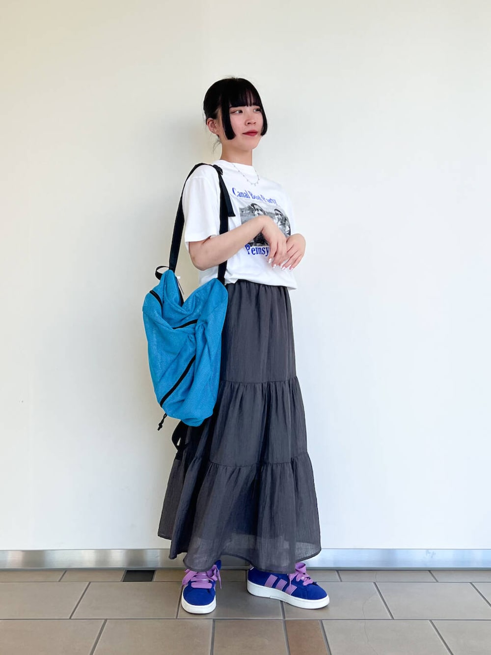 ブルー系のバックパック/リュック、ブラック系のベスト、ホワイト系のTシャツ/カットソーを着用したレディースの夏コーディネートの2枚目の写真