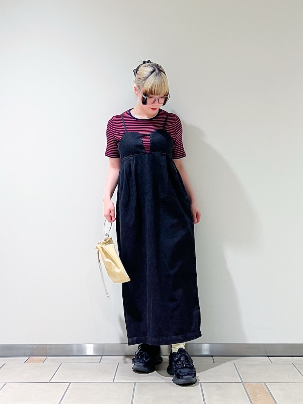 ブラック系のワンピース、イエロー系のショルダーバッグ、ブルー系のTシャツ/カットソーを着用したレディースの夏コーディネートの2枚目の写真
