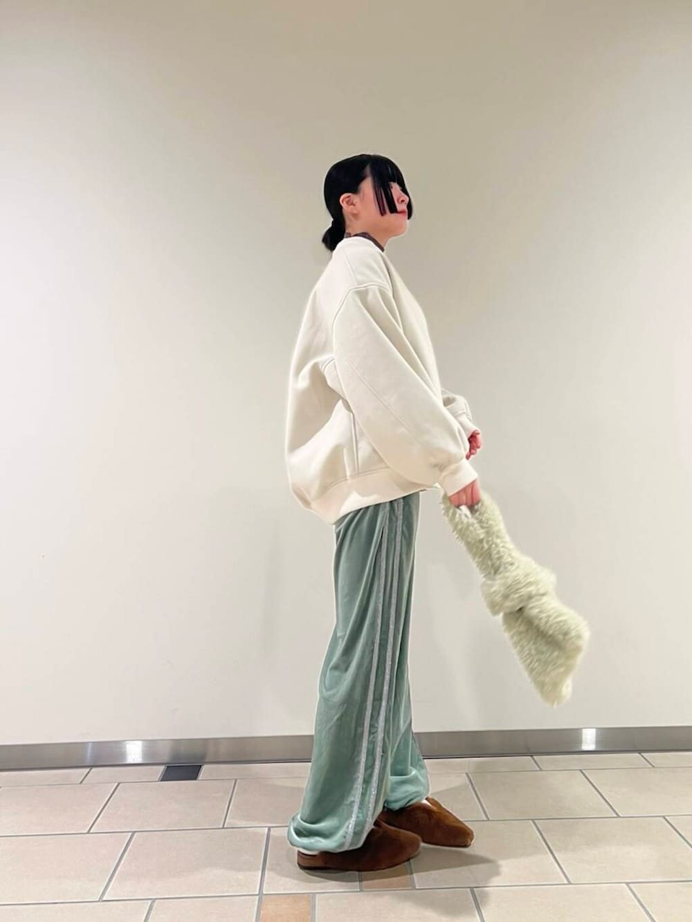 グレー系のニット/セーター、イエロー系のその他シューズ、グリーン系のその他パンツを着用したレディースの秋コーディネートの2枚目の写真