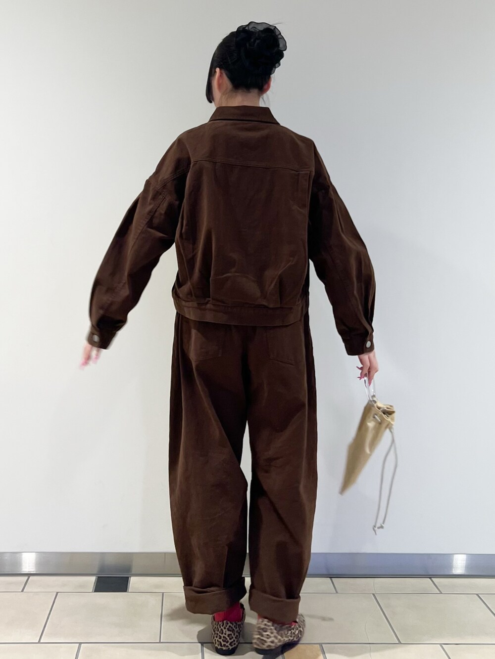 ピンク系のニット/セーター、ブラウン系のブルゾン、イエロー系のショルダーバッグを着用したレディースの冬コーディネートの3枚目の写真