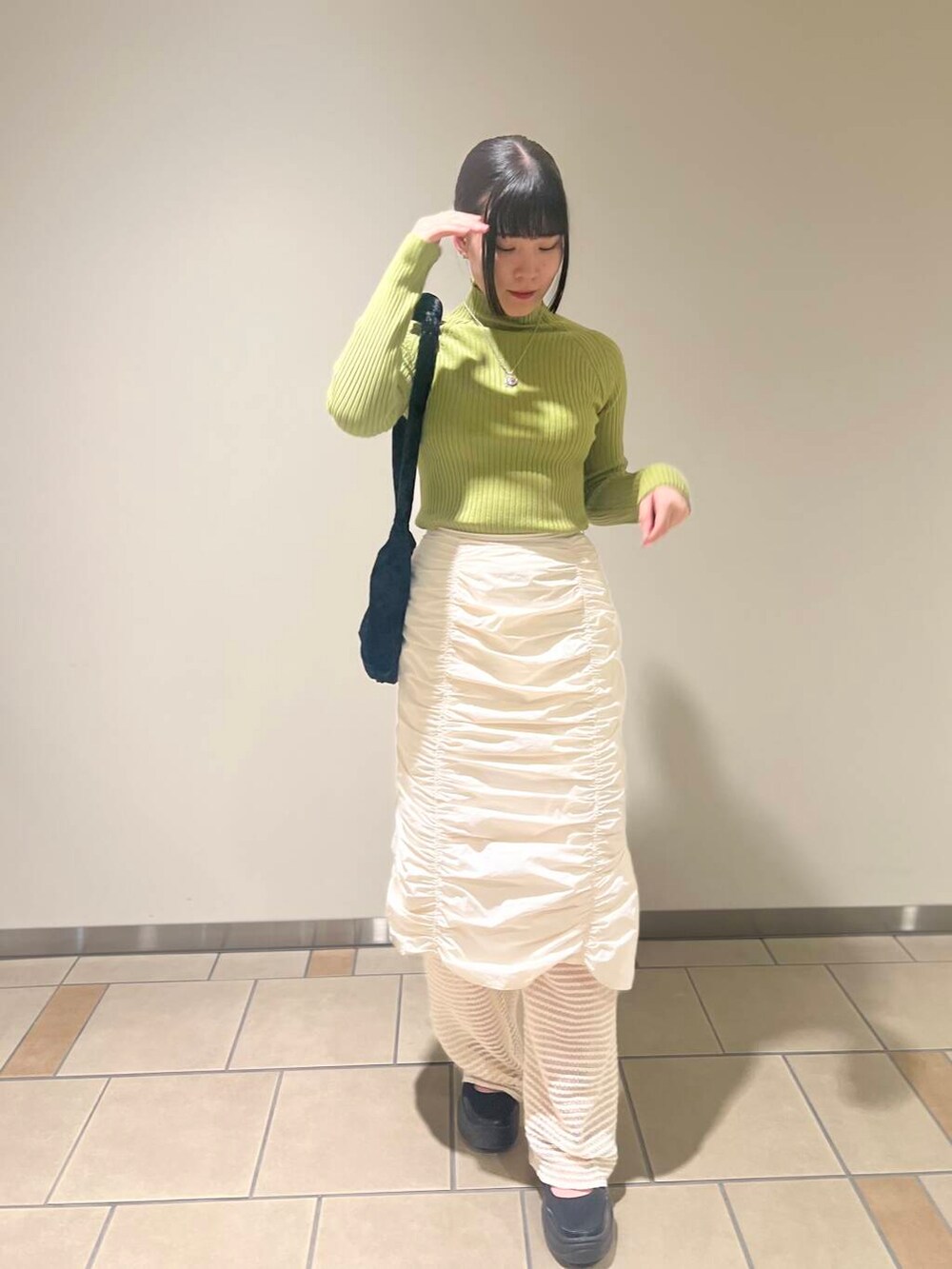 グリーン系のニット/セーター、ホワイト系のその他パンツ、ブラック系のハンドバッグを着用したレディースの秋コーディネートの2枚目の写真