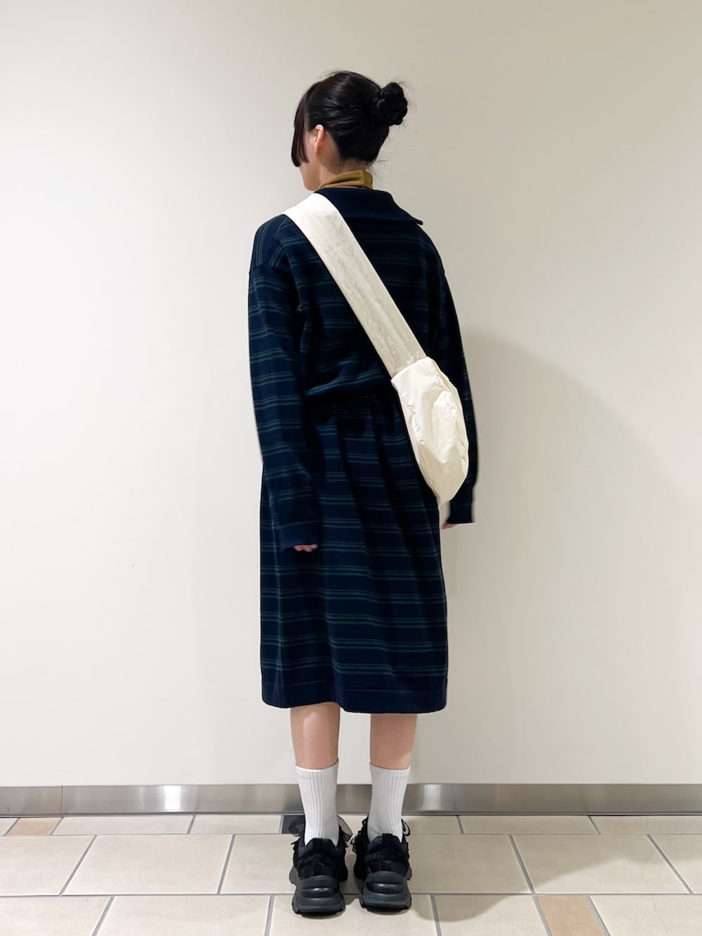 ブルー系のワンピース、イエロー系のTシャツ/カットソー、ホワイト系のショルダーバッグを着用したレディースの秋コーディネートの2枚目の写真