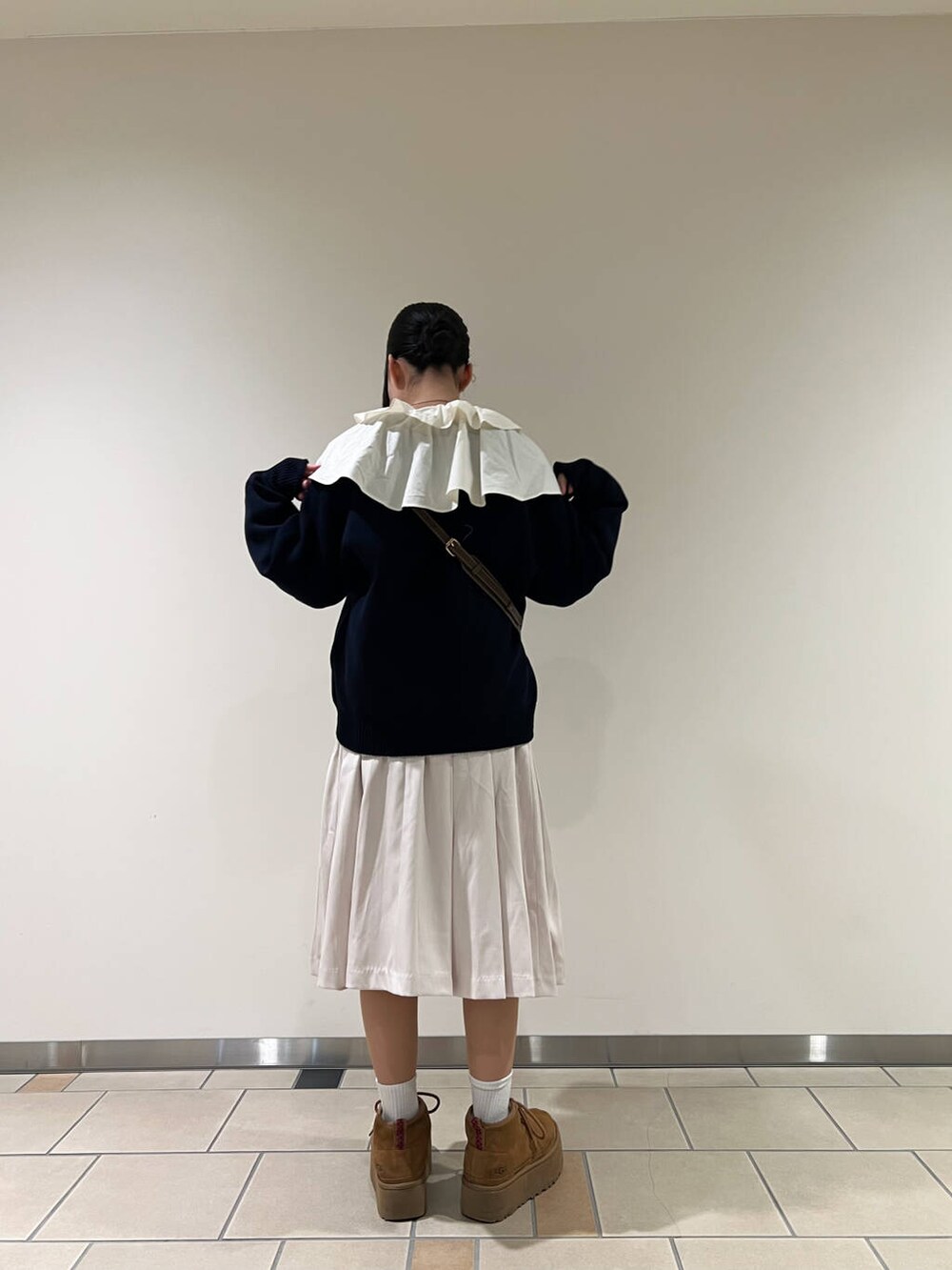 ベージュ系のハンドバッグ、グレー系のスカート、ホワイト系のシャツ/ブラウスを着用したレディースの冬コーディネートの2枚目の写真