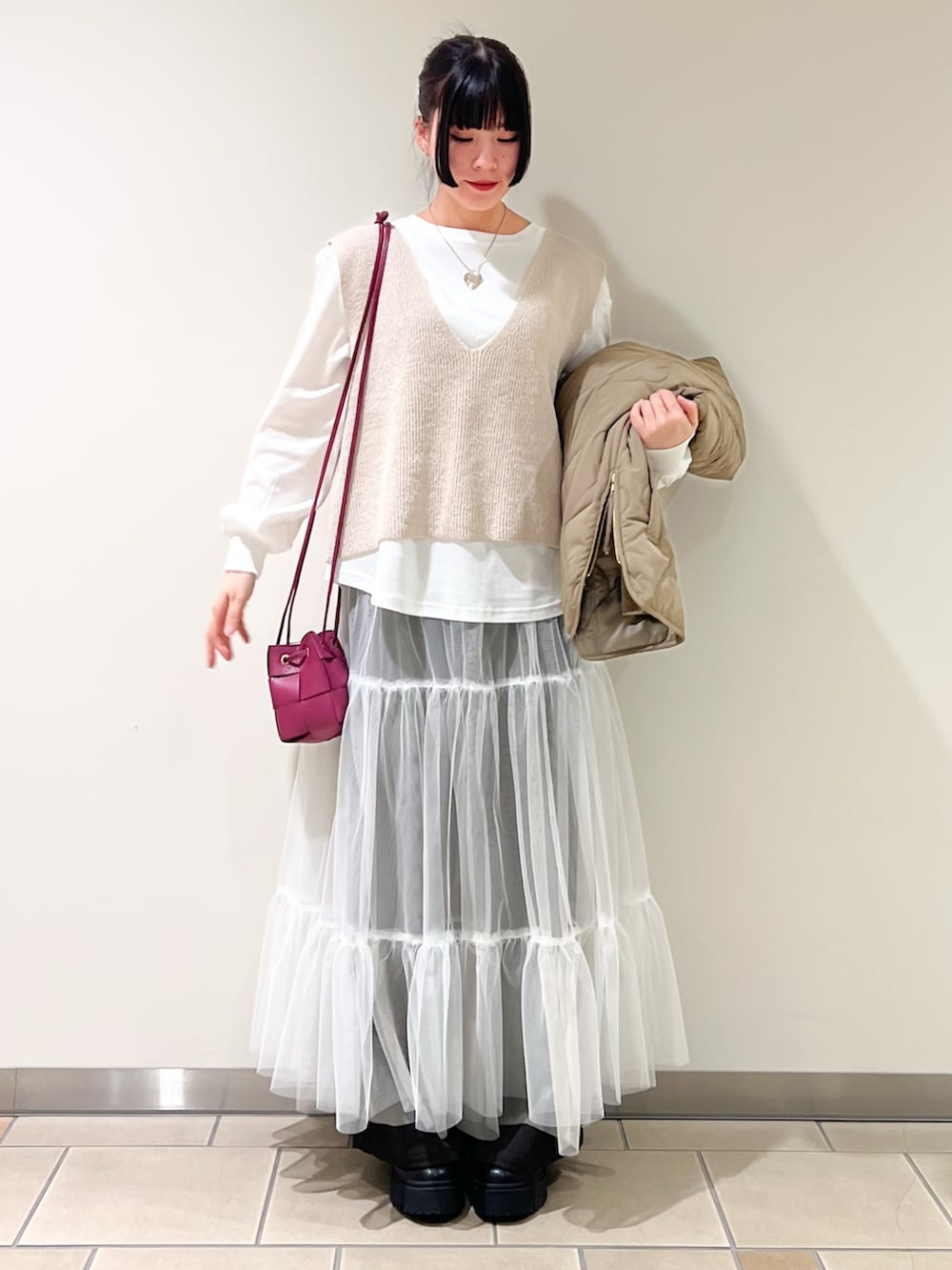 ブラウン系のその他パンツ、ホワイト系のスカート、グリーン系のブルゾンを着用したレディースの冬コーディネートの3枚目の写真