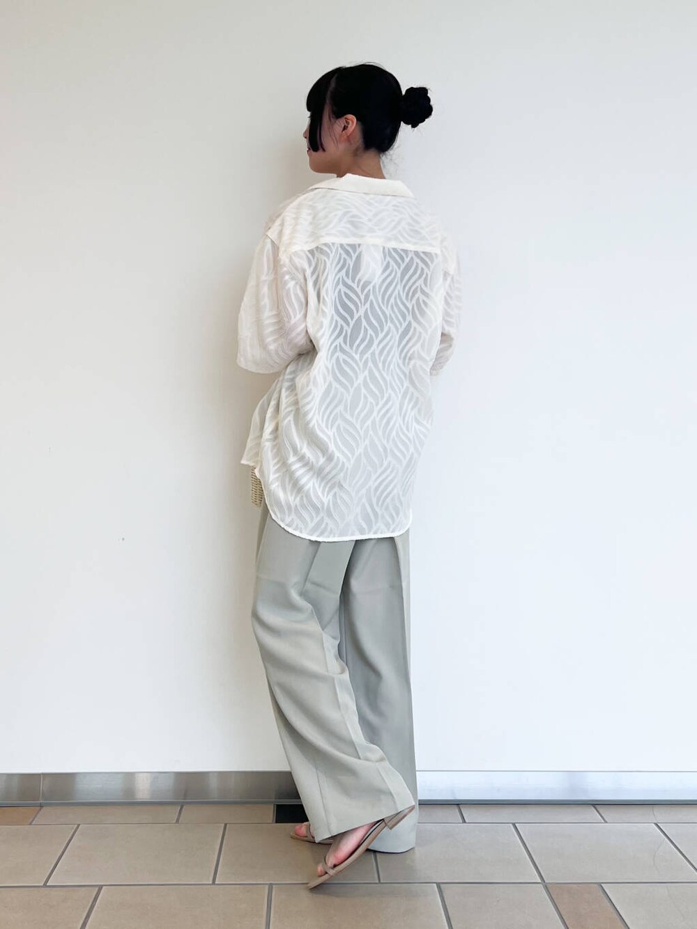 グレー系のサンダル、ホワイト系のハンドバッグ、ブラウン系のタンクトップを着用したレディースの夏コーディネートの2枚目の写真