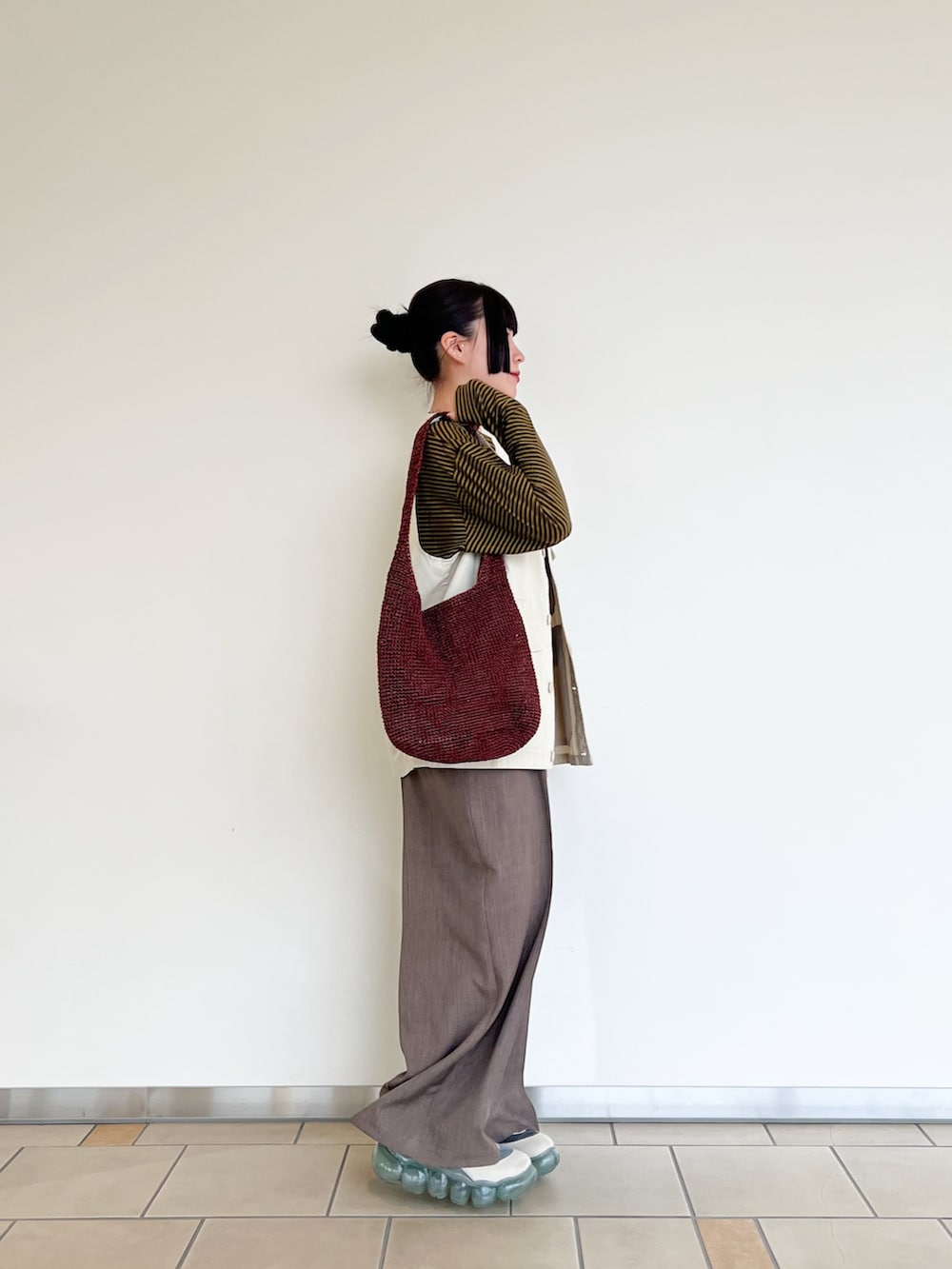 ブラウン系のTシャツ/カットソー、ホワイト系のベスト、ブラウン系のその他パンツを着用したレディースの春コーディネートの4枚目の写真