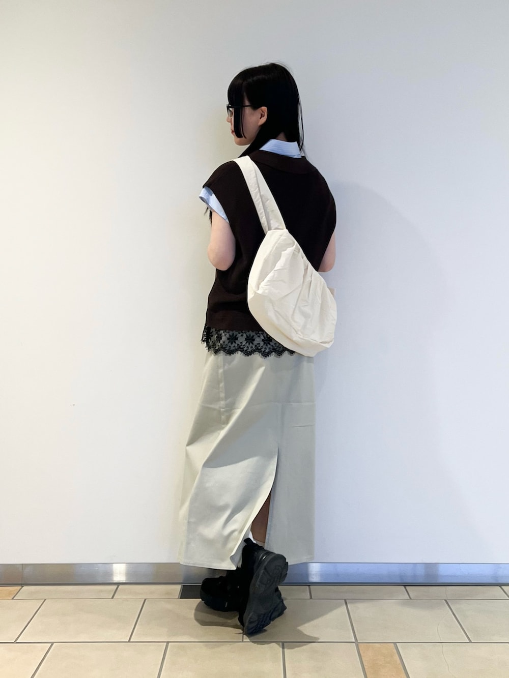 ブルー系のシャツ/ブラウス、ブラウン系のニット/セーター、ベージュ系のスカートを着用したレディースの春コーディネートの2枚目の写真