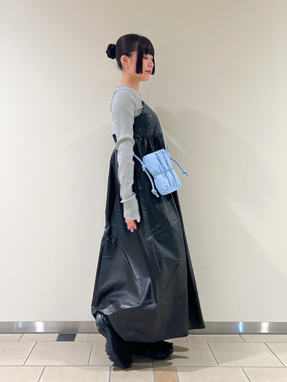 ブルー系のショルダーバッグ、ブラック系のワンピースを着用したレディースの秋コーディネートの2枚目の写真