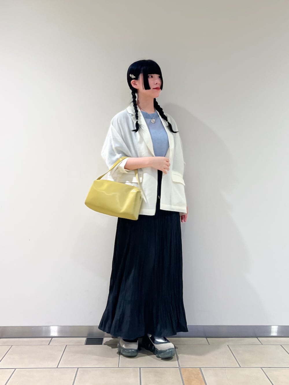ブルー系のニット/セーター、ホワイト系のその他アウター、グレー系のスカートを着用したレディースの春コーディネートの2枚目の写真