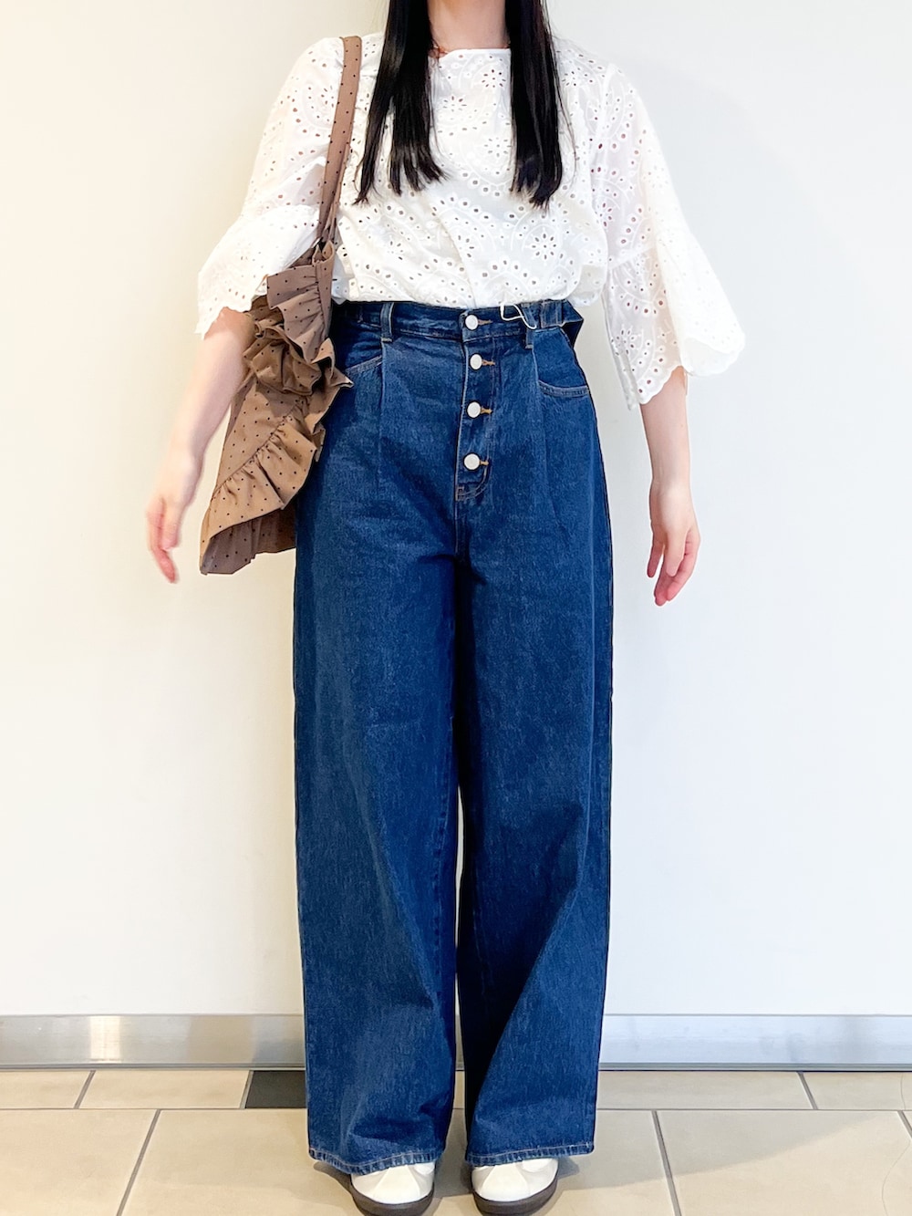 ベージュ系のトートバッグ、ブルー系のデニムパンツ、ホワイト系のシャツ/ブラウスを着用したレディースの春コーディネートの2枚目の写真