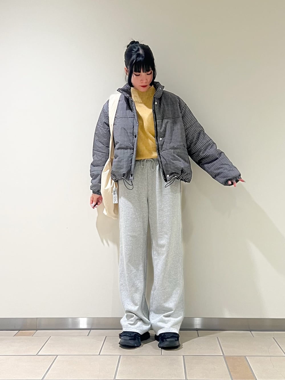 その他のダウンジャケット/コート、イエロー系のニット/セーター、グレー系のその他パンツを着用したレディースの秋コーディネートの2枚目の写真